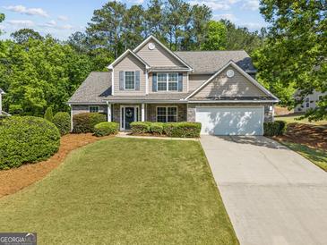 Charming two-story home featuring a well-manicured lawn, two-car garage, and inviting curb appeal at 3129 Oak Ridge Ln, Loganville, GA 30052