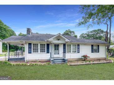 Charming single-story home with white siding, black shutters, and well-maintained lawn at 1236 Stone Mountain Lithonia Rd, Lithonia, GA 30058