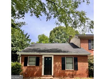 Charming brick home featuring classic black shutters and a well-manicured lawn at 4712 Rockstile Way, Stone Mountain, GA 30083