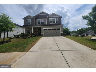Charming two-story home with a well-manicured front lawn and a two-car garage at 883 Ironhorse Sw Ln, Mableton, GA 30126