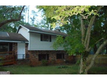 Two-story home with vinyl siding and a brick foundation, nestled among mature trees at 3296 Columbia Woods Dr, Decatur, GA 30032