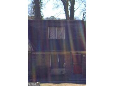Townhouse exterior with brick facade, red door, covered entryway, and multi-pane windows at 79 Peyton Sw Pl, Atlanta, GA 30311