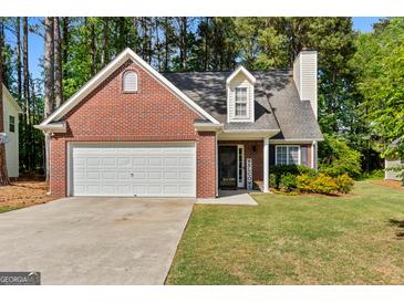 Charming brick home featuring a two-car garage, manicured lawn, and lovely landscaping at 140 Braymoor Cir, Fayetteville, GA 30215