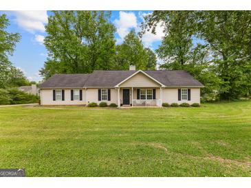 Charming ranch-style home featuring a well-manicured lawn, classic shutters, and a welcoming front porch at 75 Mcintosh Estates Dr, Sharpsburg, GA 30277