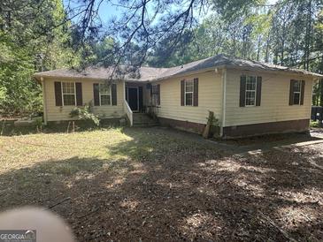 Ranch-style home with charming shutters and ample yard space, awaiting your personal touch at 30 Woodfield Rd, Covington, GA 30014
