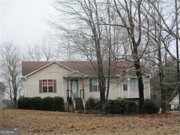 Inviting single-Gathering home featuring a well-maintained lawn, mature landscaping, and a cozy front entrance at 185 Cross Plains Hulett Rd, Carrollton, GA 30116