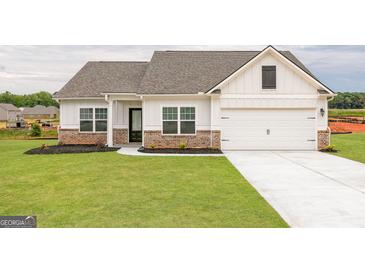 Beautiful one story home with white siding, brick accents, and a well manicured lawn at 239 Oliver Dr, Locust Grove, GA 30248