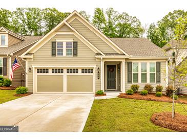 Charming home featuring a two-car garage, manicured lawn, and a welcoming front porch at 444 Silverbell Ct, Peachtree City, GA 30269