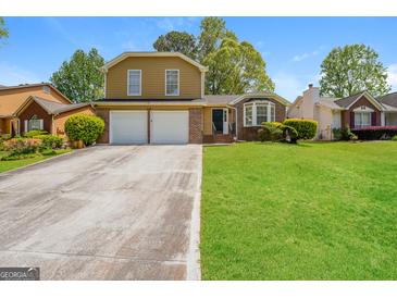 Traditional two-story home with a two-car garage and well-maintained front yard at 3913 Landgraf Cv, Decatur, GA 30034
