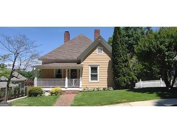 Charming two-story home featuring a welcoming front porch, well-maintained lawn and manicured landscaping at 2897 Macaw Nw St, Atlanta, GA 30318