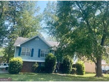 Charming two-story home with a well-manicured lawn and mature trees at 6012 Happy Trls Ct, Lithonia, GA 30058