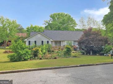 Charming single-story home featuring a well-manicured lawn and inviting front deck at 125 Burnside St, Jonesboro, GA 30236