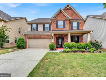 Charming two-story brick and tan home with a manicured lawn and attached two-car garage at 3259 Baylor Cir, Mcdonough, GA 30253