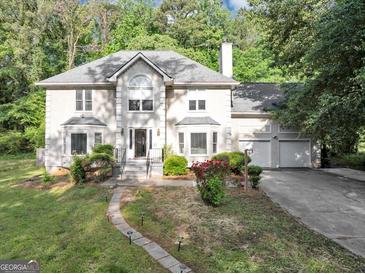 Beautiful home featuring a well-manicured front lawn and charming walkway to a covered front porch at 5045 Rock Springs Rd, Lithonia, GA 30038