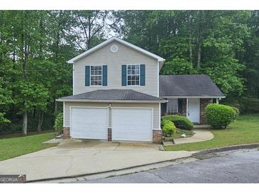 Charming two-story home with a two-car garage and beautiful, lush landscaping at 5851 Giles Rd, Lithonia, GA 30058