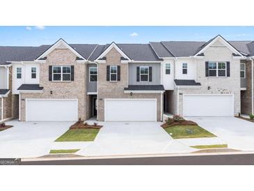 Modern townhomes featuring brick and siding exteriors and attached two-car garages at 100 Silver Moon Dr, Loganville, GA 30052