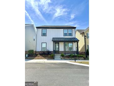 Charming two-story home featuring a covered porch, black accents and low maintenance landscaping at 4438 Encore Park Xing, Duluth, GA 30097