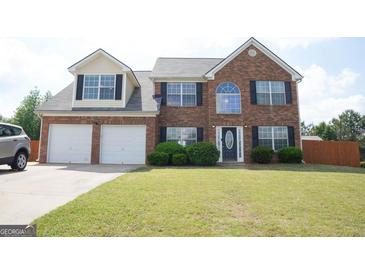 Charming two-story brick home with a well-manicured lawn and attached two-car garage at 65 Heaton Place Trl, Covington, GA 30016