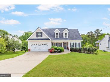 Charming two-story home featuring a well-manicured lawn and attached two-car garage at 447 W Wind Dr, Villa Rica, GA 30180