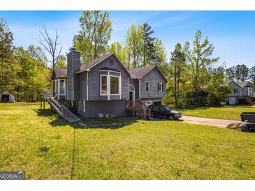 Two-story home featuring an attached garage, gray exterior, bay window, and a walkway leading to the front door at 231 Breckenridge Ln, Powder Springs, GA 30127