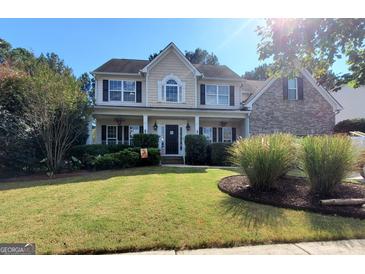 Charming two-story home featuring manicured lawn and inviting front porch at 976 Buckhorn Bnd, Locust Grove, GA 30248