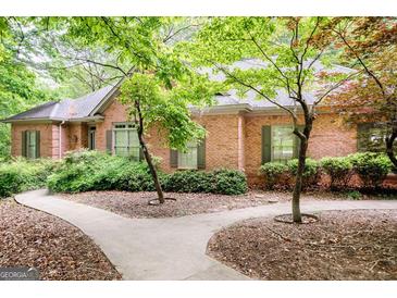Charming brick home featuring a well-maintained lawn and mature trees at 260 Emerald Lake Dr, Fayetteville, GA 30215