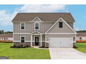 Two-story home featuring a light gray exterior, a two-car garage, and a well-manicured lawn at 240 Oliver Dr, Locust Grove, GA 30248