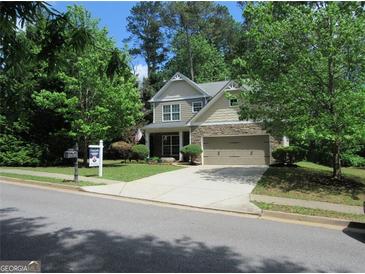 Charming two-story home featuring a stone and siding facade, manicured lawn, and attached two-car garage at 4832 Batiste Ln, Acworth, GA 30101