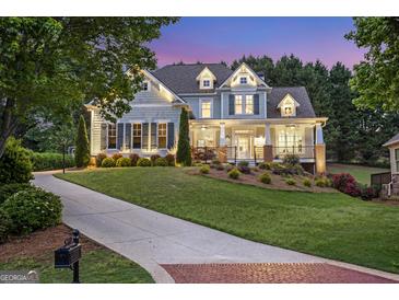 Beautiful two-story home with a well-manicured lawn and inviting front porch at dusk at 8710 Gilmer Ft, Cumming, GA 30028