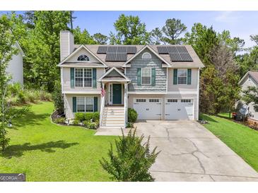 Charming home with a two-car garage, solar panels, and a well-manicured front yard at 103 Manx Dr, Grantville, GA 30220