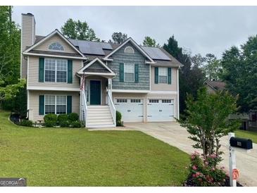 Charming two-story home with solar panels, green lawn, and a two car garage at 103 Manx Dr, Grantville, GA 30220