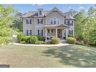 Traditional two-story home with a manicured lawn, dormer windows and inviting covered front porch at 335 Discovery Lake Dr, Fayetteville, GA 30215