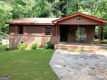 Single story house with brick foundation and brown siding surrounded by trees at 6154 Green Acres Sw Dr, Covington, GA 30014