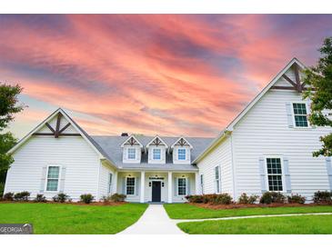 Stunning exterior showcasing a manicured lawn, charming shutters, and inviting entrance under a beautiful sunset at 368 Ginger Cake Rd, Fayetteville, GA 30214