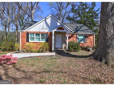 Charming brick home features a front porch, mature trees, and landscaped front yard at 3464 Wren Rd, Decatur, GA 30032