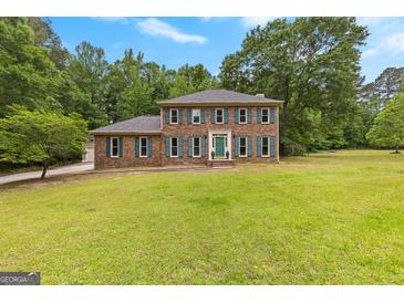 Stately brick two-story home with a large front yard and lush trees at 155 Grandview Trce, Fayetteville, GA 30215