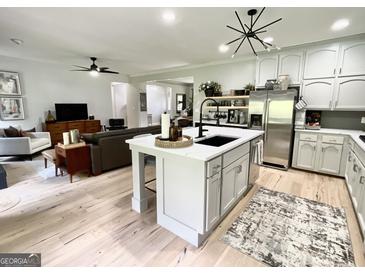 Bright kitchen with island seating, stainless steel appliances, light cabinets, and open floor plan at 109 Old Virginia Cir, Jonesboro, GA 30236