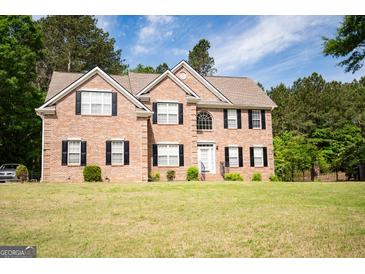 Charming two-story brick home with black shutters, well-manicured lawn, and classic architectural details at 105 Kellens Ct, Fayetteville, GA 30215