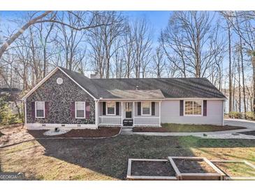Charming home featuring stone facade, inviting front porch, and landscaping at 84 Contour Dr, Stockbridge, GA 30281