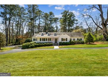 Charming single-story home with a well-manicured lawn and mature trees at 1664 W Wesley Nw Rd, Atlanta, GA 30327