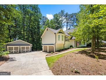 Charming home with a detached garage, lush landscaping, and a welcoming entrance at 760 Swan Ln, Canton, GA 30115