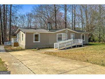 Charming single-story home with a well-maintained lawn and a ramp leading to the front entrance at 261 Lakeview Dr, Locust Grove, GA 30248