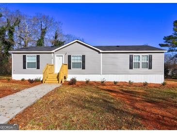 Charming single-story home featuring gray siding, black shutters, and a well-maintained front yard at 36 Highpoint Ln, Locust Grove, GA 30248