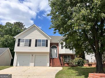 Charming two-story home with white siding, black shutters, two-car garage, and a well-manicured lawn at 11616 Spring Lake Way, Fayetteville, GA 30215
