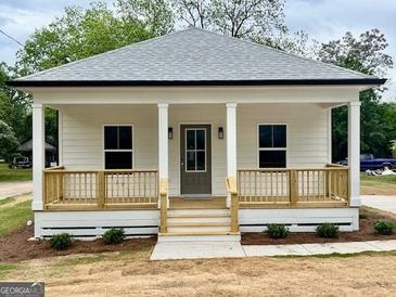 Charming home showcasing a covered front porch, white siding, and craftsman columns at 304 N Dogwood Ave, Social Circle, GA 30025