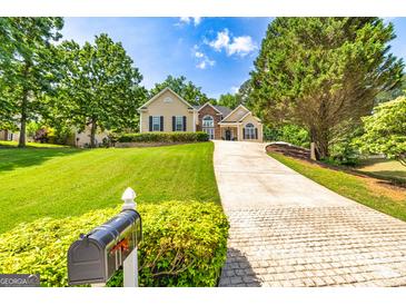 Traditional home with well-maintained landscaping, charming curb appeal, and a long driveway leading to the residence at 120 Lyndhurst Way, Sharpsburg, GA 30277