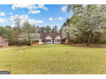 Charming home with a manicured lawn and flowering trees on a sunny day at 195 Blackberry Run, Fayetteville, GA 30214