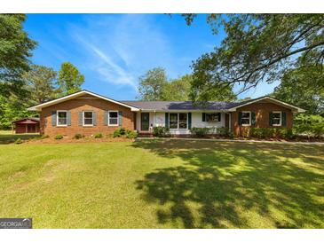 Charming single-story brick home with a lush lawn and mature trees creating a peaceful setting at 270 Lake Cir, Fayetteville, GA 30215
