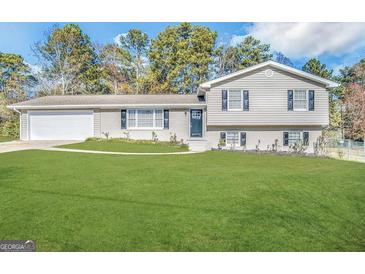 Charming split-level home with gray brick, mature trees and an expansive green lawn at 5906 Pine Hurst Way, Douglasville, GA 30135