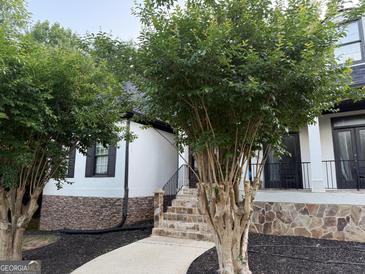 Charming home entrance featuring stone accents and a well-manicured yard, offering a welcoming curb appeal at 119 Glen Eagle Way, Mcdonough, GA 30253